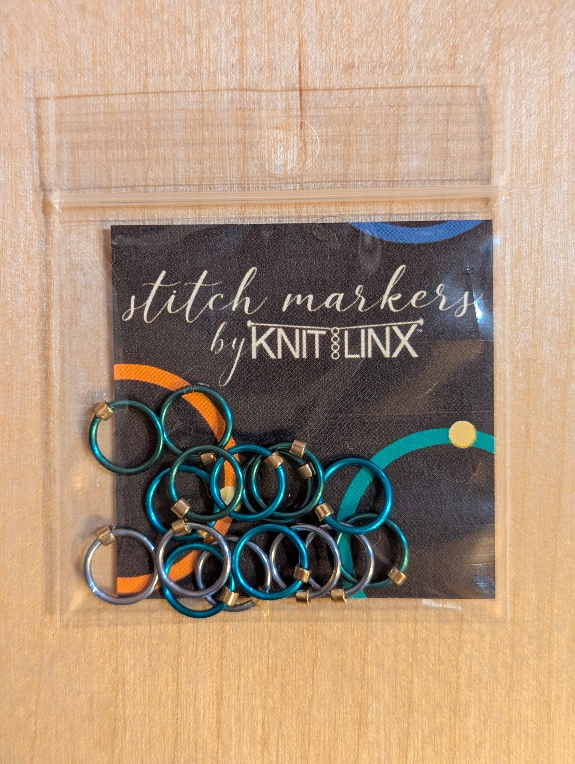 Knitting or crocheting stitch markers by KnitLinx for knitting needles size 0 though 8. Made from metal in silver and teal blue