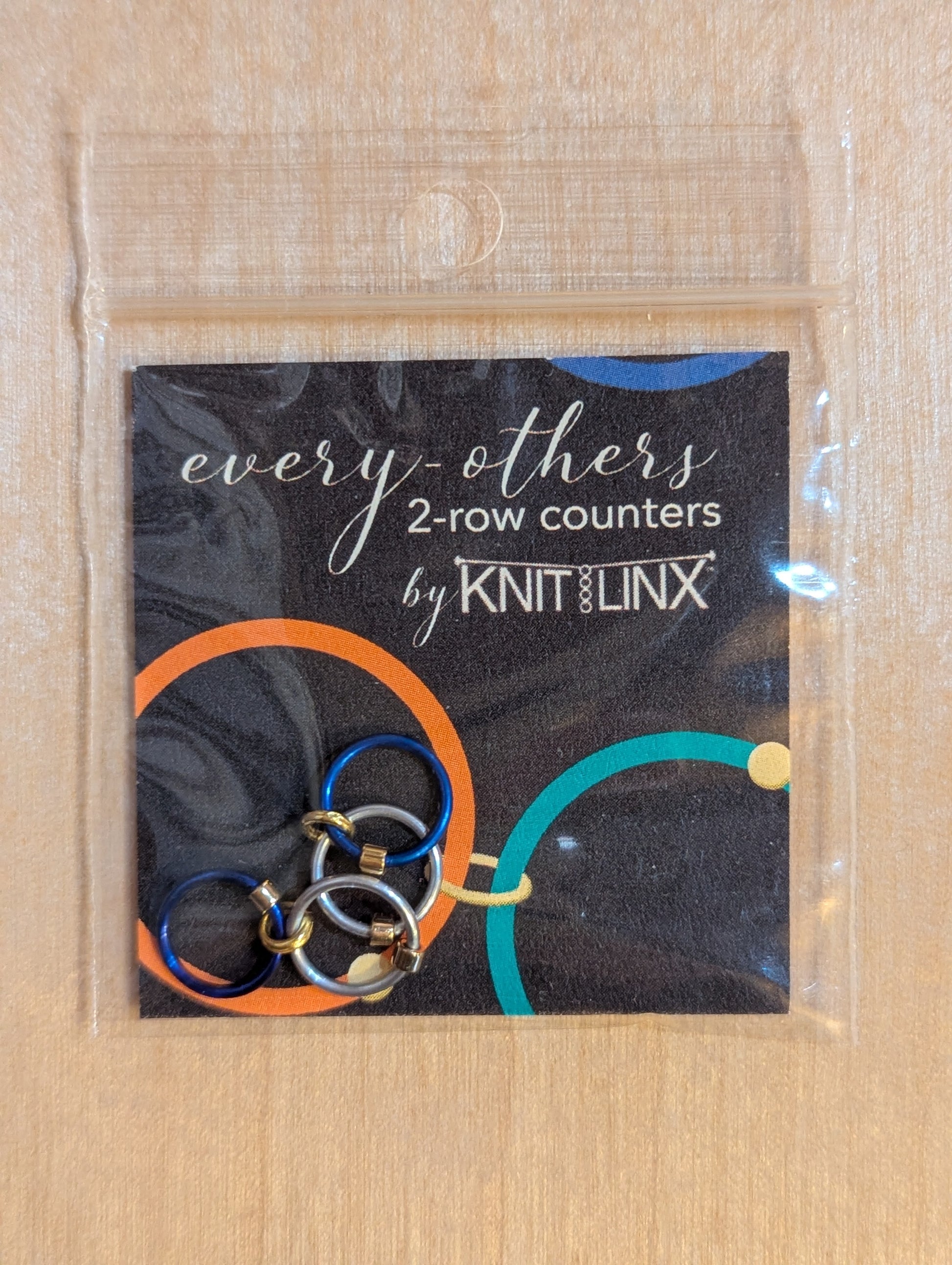 Packaged product of 'every others' 2-row counters by Knit LINX for knitting needles size 0 through 8 in silver and blue colors.