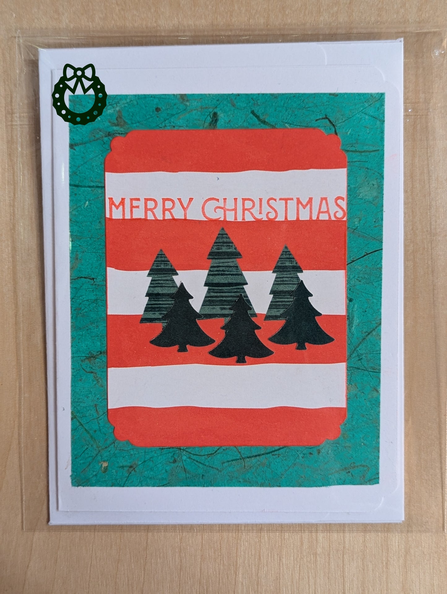 Christmas card with red and green design featuring trees and 'Merry Christmas'