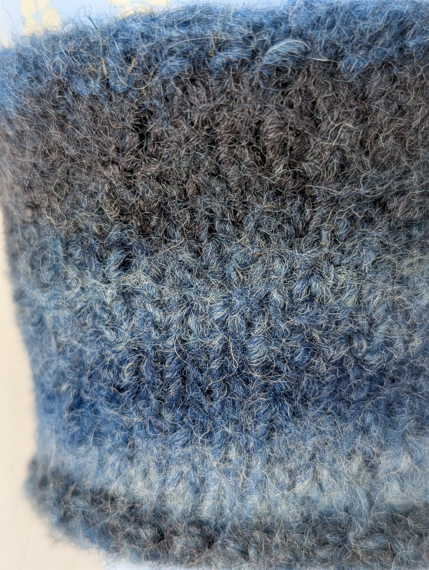 Close-up of a knitted and felted blue and gray color gradient mug cozy