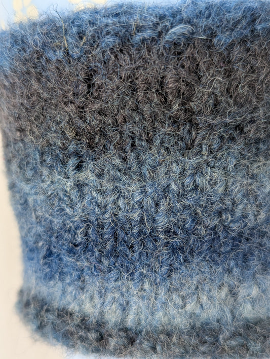 Close-up of a knitted and felted blue and gray color gradient mug cozy
