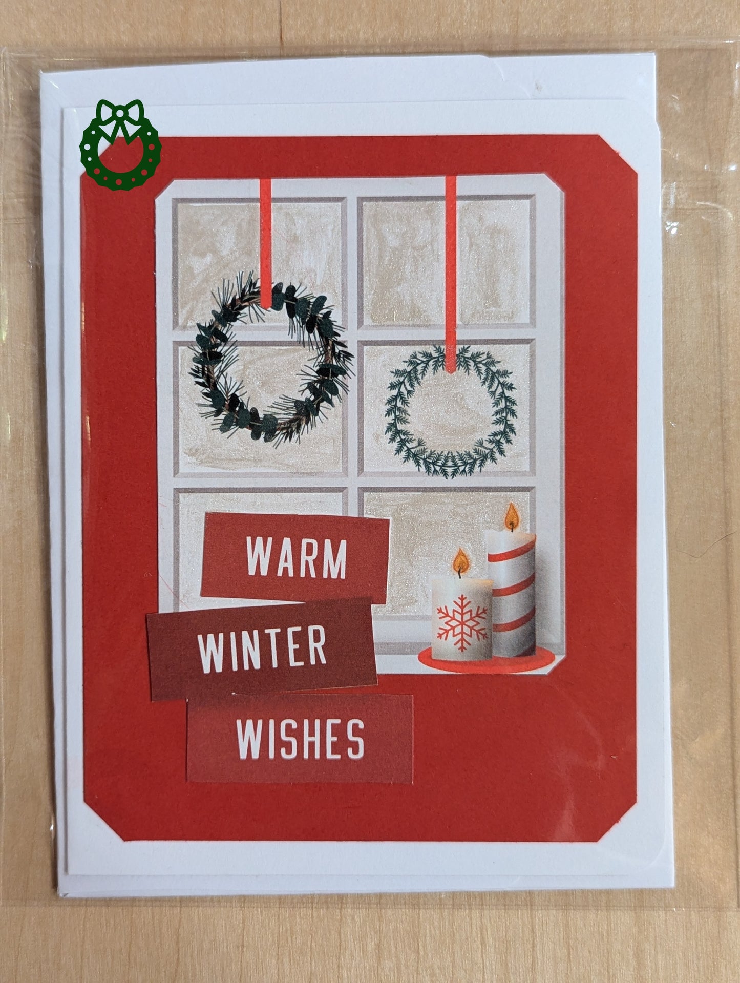 Christmas card with window scene, wreaths, and candles on a red background