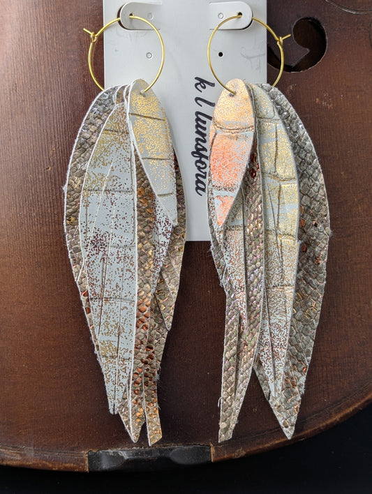 Vegan leather feather shaped dangle earrings. Bronze, gold, silver and white with gold hoops. 5.5 inches long.