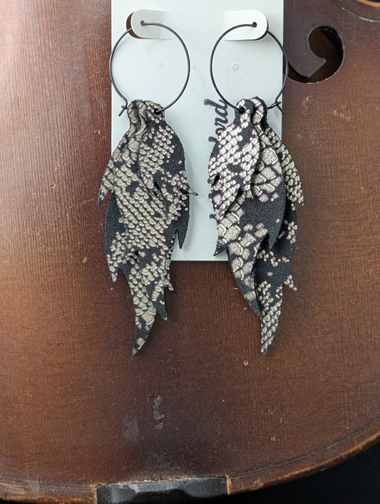 Leather earrings. Black and silver flame shaped pieces on black hoops. 4 inches long.