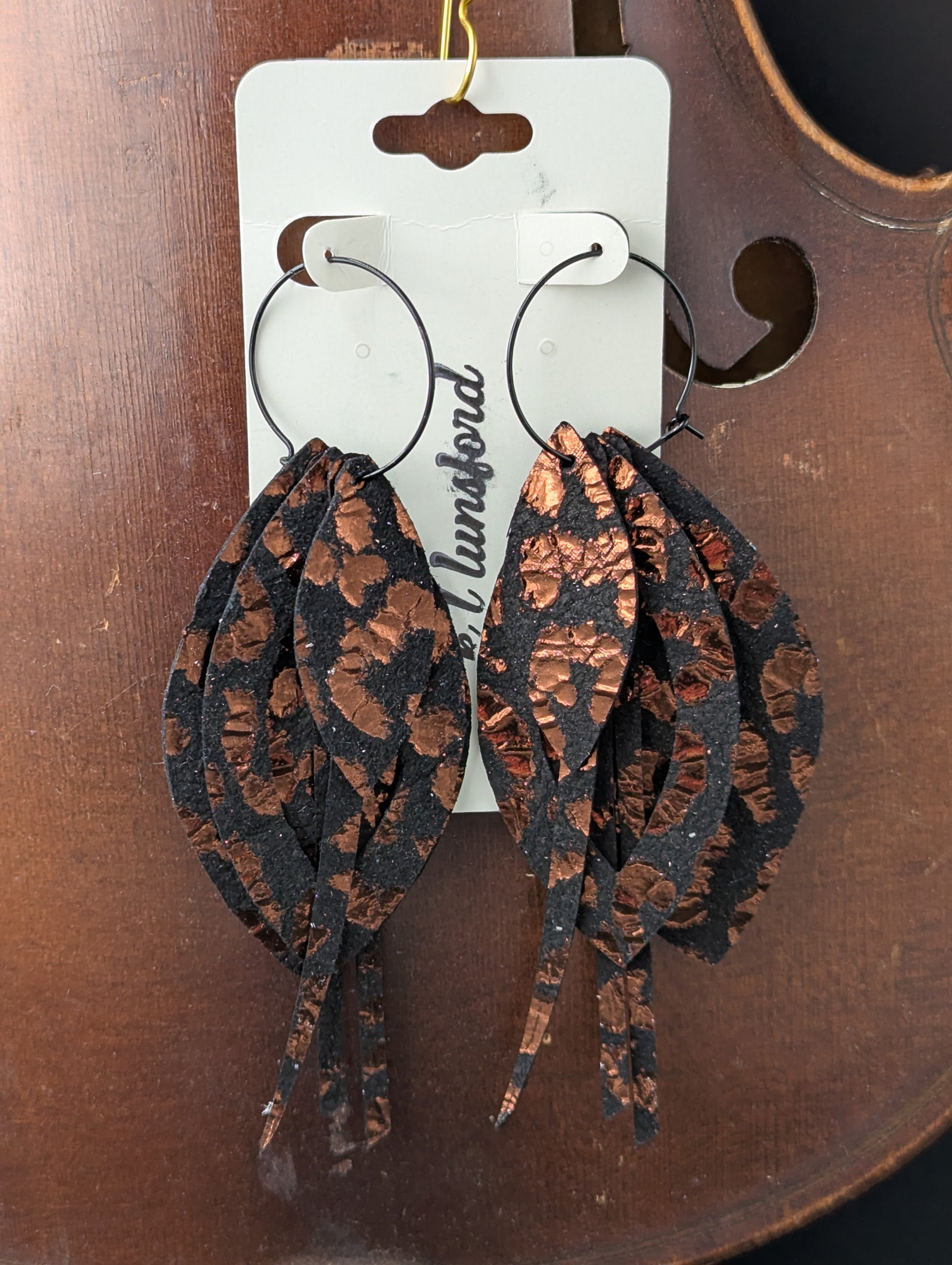Leather earrings. Black and copper drop and strand shapes with black hoops. 4.5 inches long.