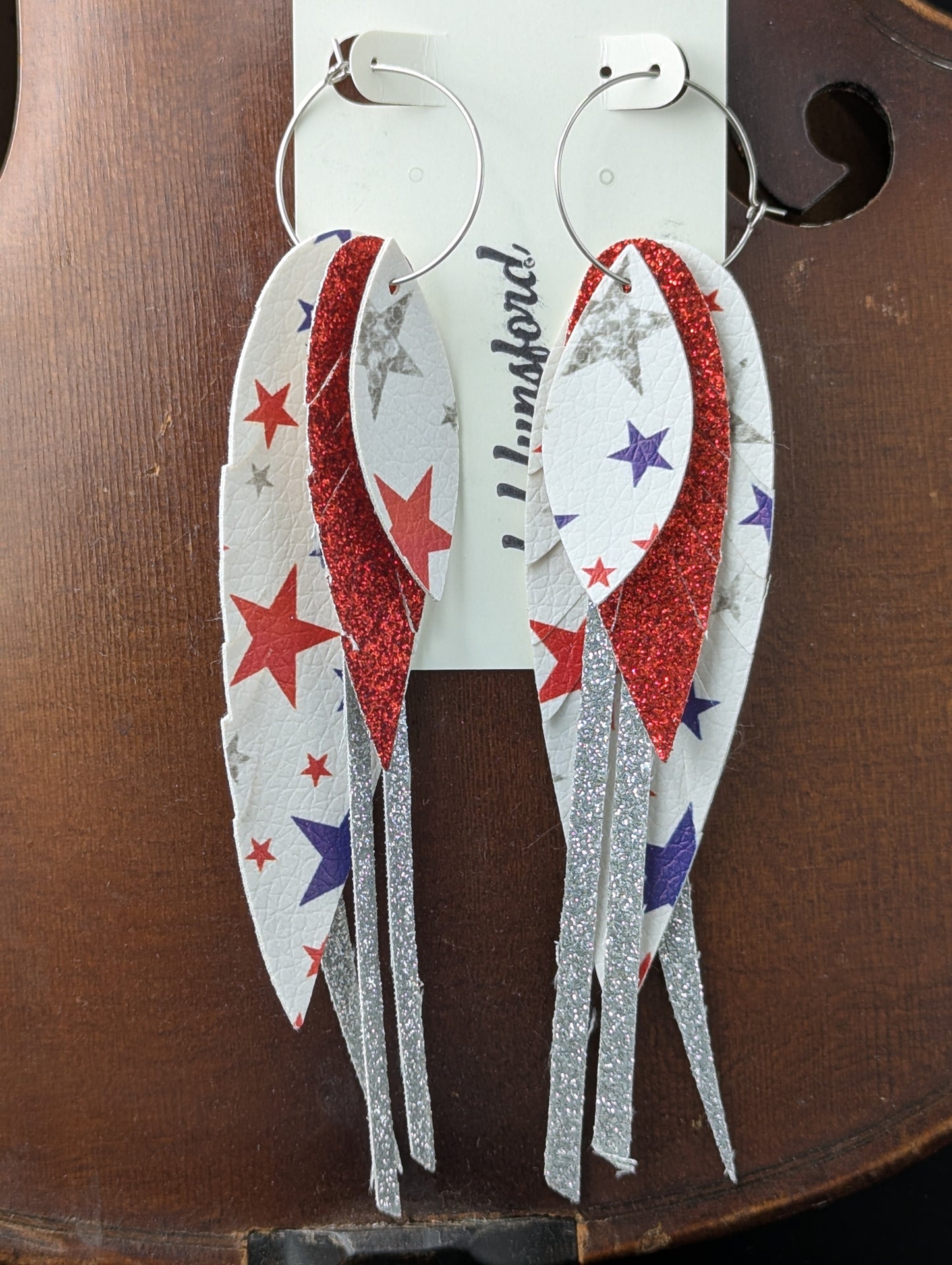 Patriotic holiday earrings. Leather earrings in red, white, blue and silver with stars and sparkles on silver hoops. 5 inches in length.