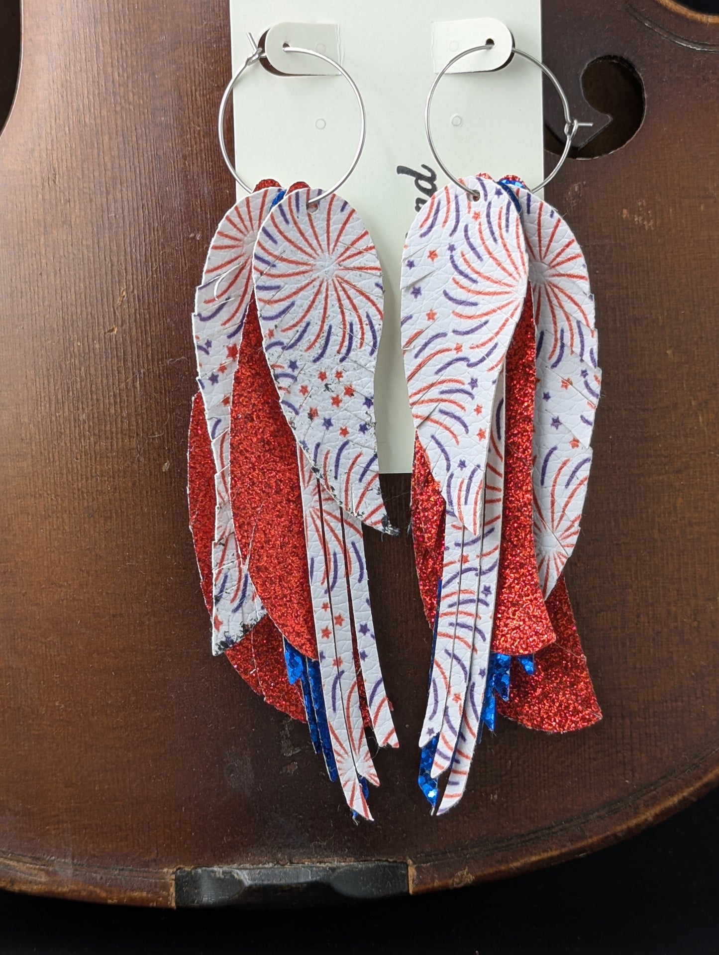 Patriotic earrings. Red, white and blue sparkly leather earrings with firework patterns on silver hoops. 5 inches in length