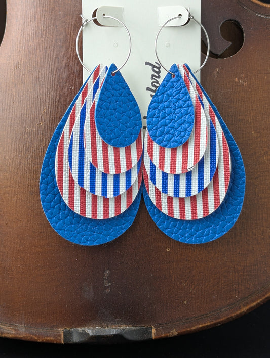 Leather teardrop-shaped earrings with red, white, and blue stripes and solid blue leather on silver hoops. 4 inches in length.