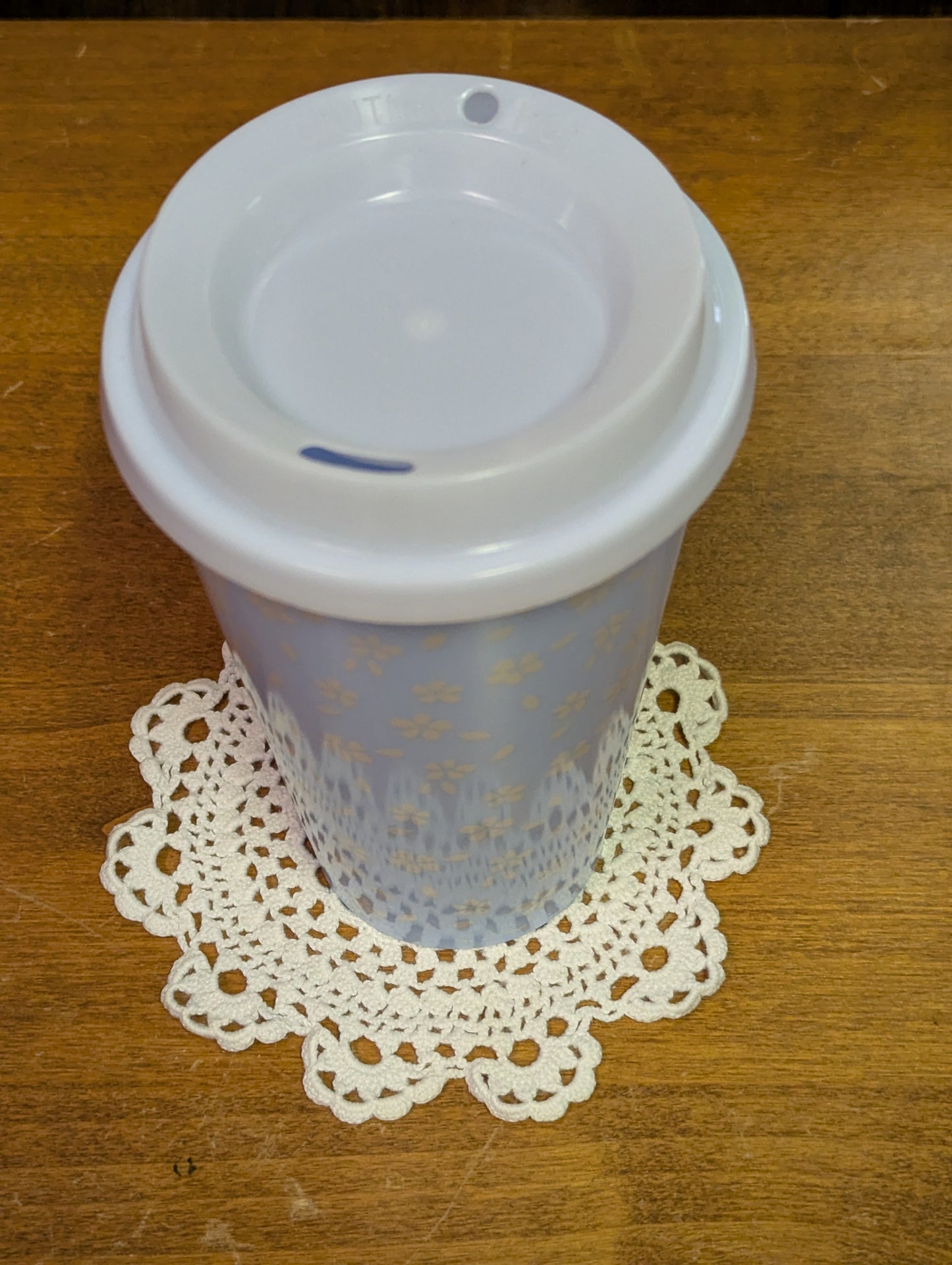Hand crochet coaster in a medallion pattern with a mug for example