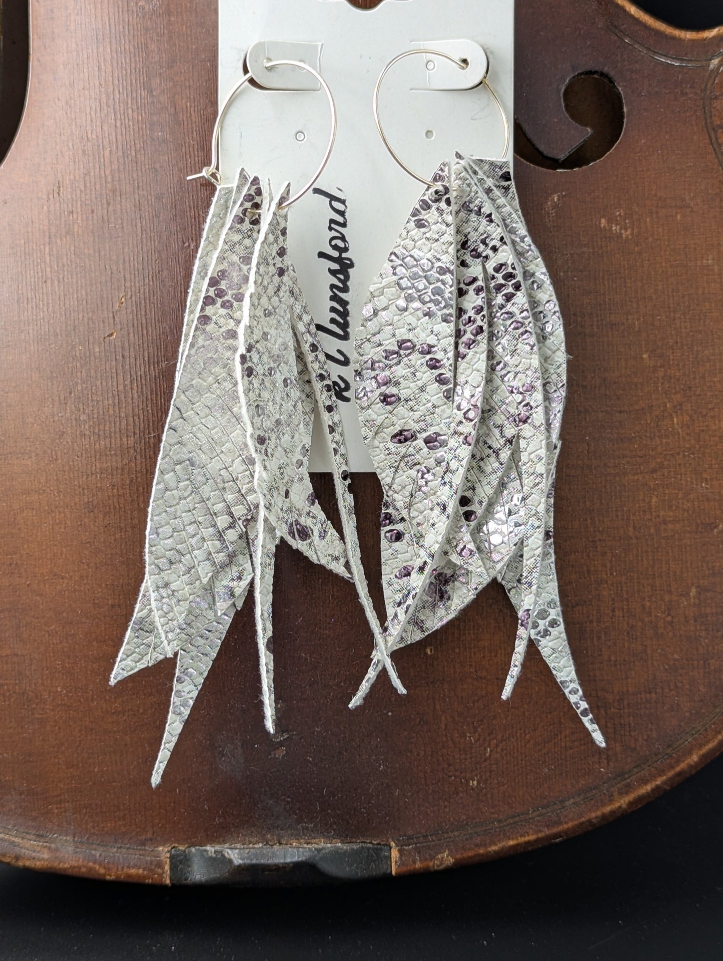 Vegan leather earrings. White, black and silver in feather shapes on delicate gold hoops. 5 inches in length
