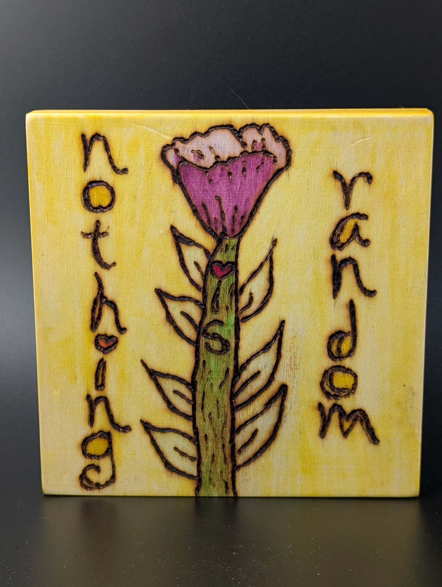 Uplifting affirmation "nothing is random" woodburned onto a small plaque