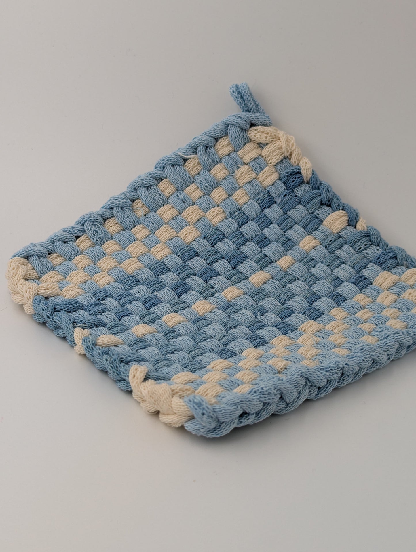 Hand woven pot holder in shades of blue and cream