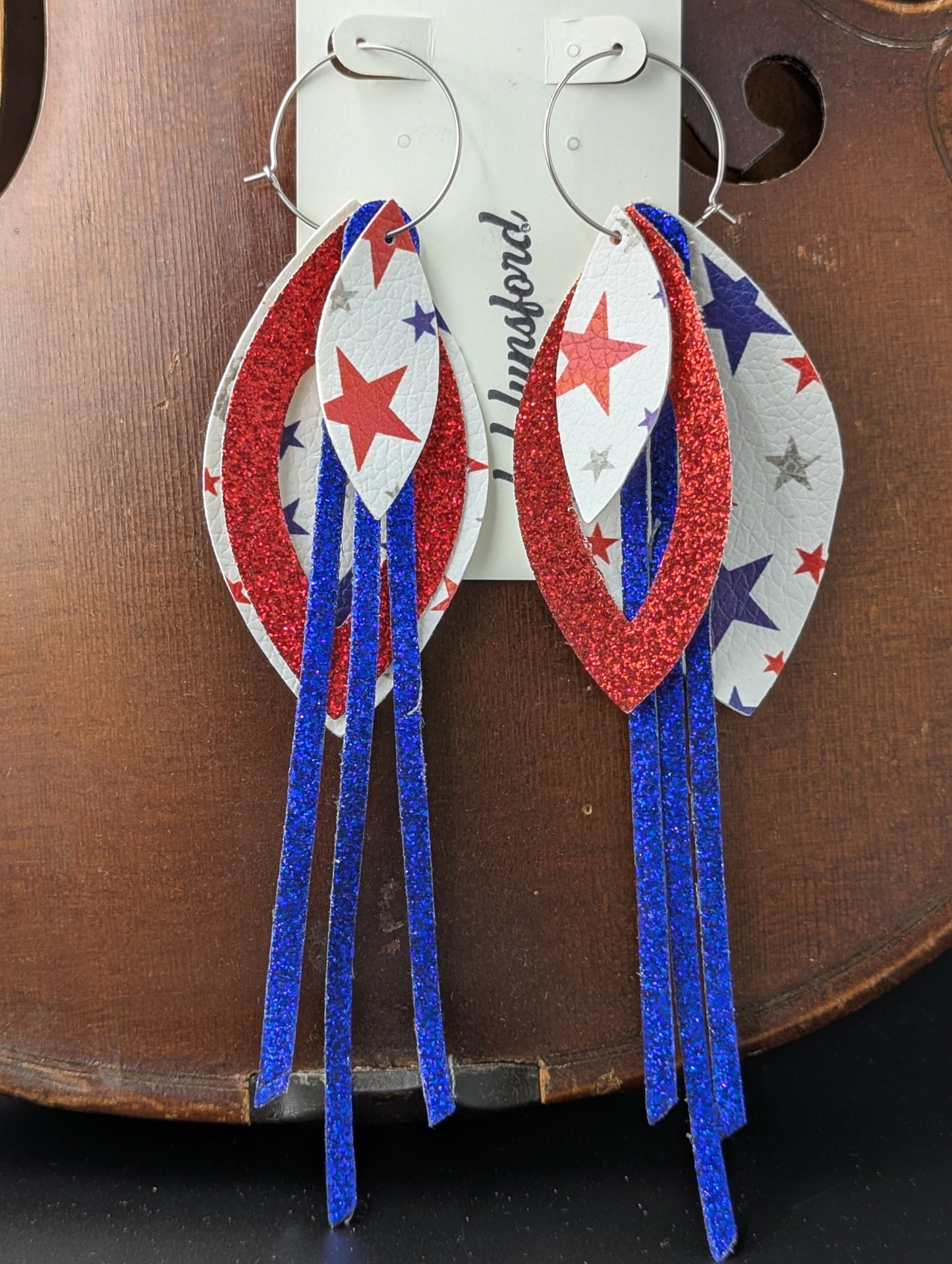 Leather earrings on silver hoops. Red, white and blue with sparkles and stars. 6 inches in length.