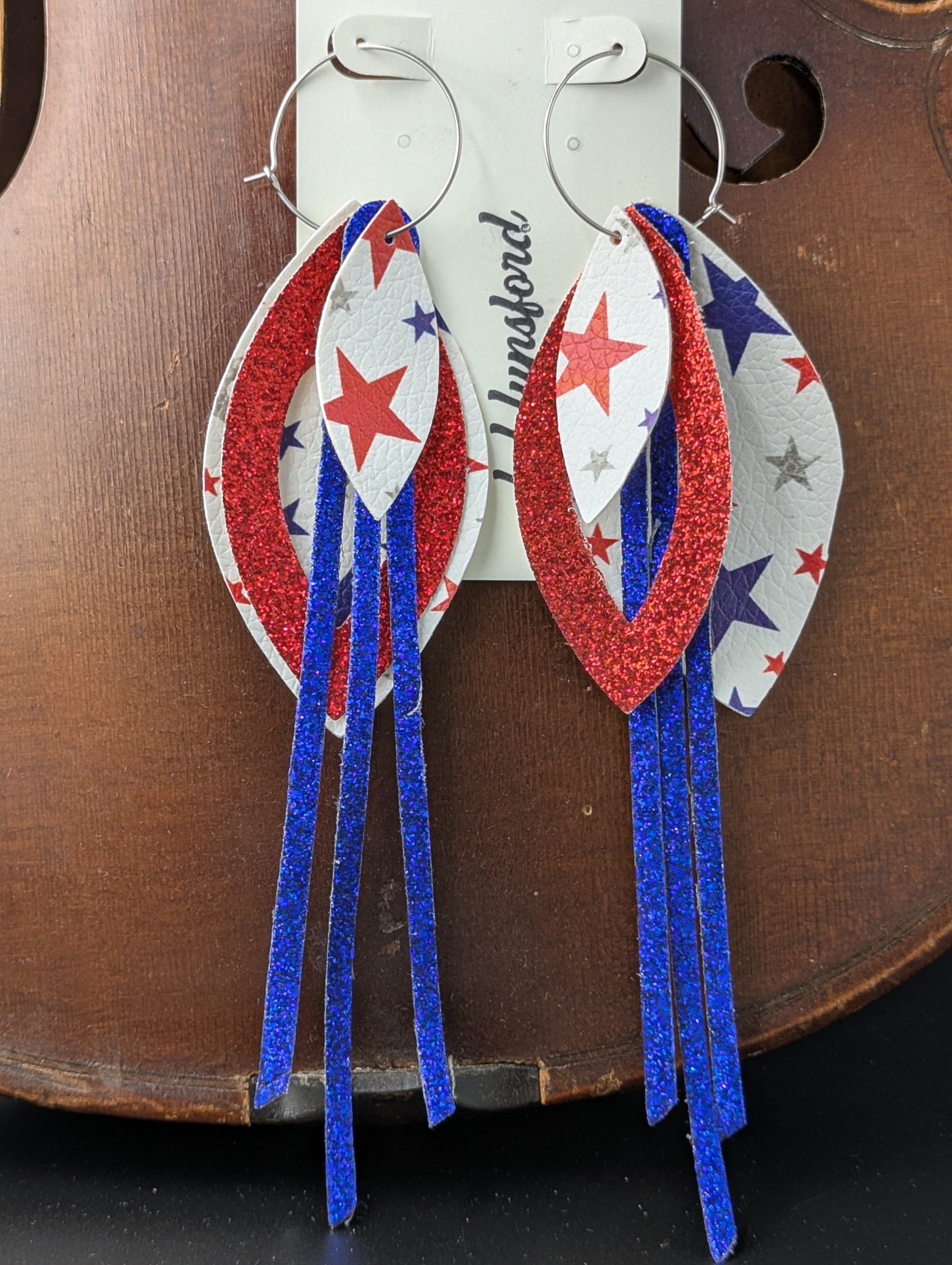 Leather earrings on silver hoops. Red, white and blue with sparkles and stars. 6 inches in length.
