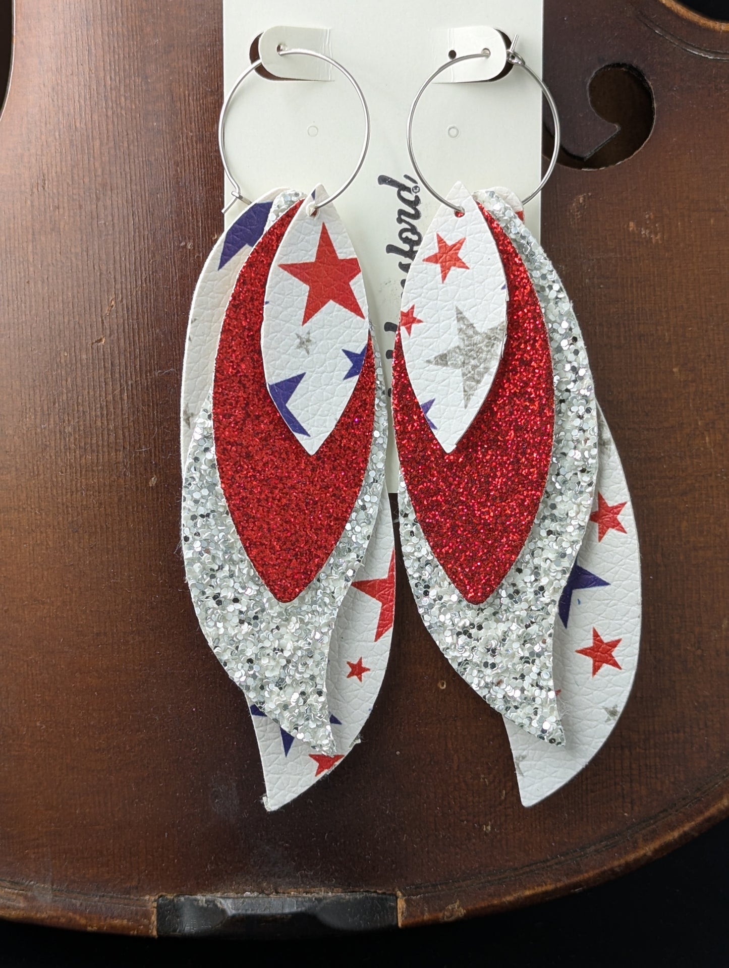 Leather earrings on silver hoops. Red, white, blue and silver with sparkles and stars. 5 inches in length.