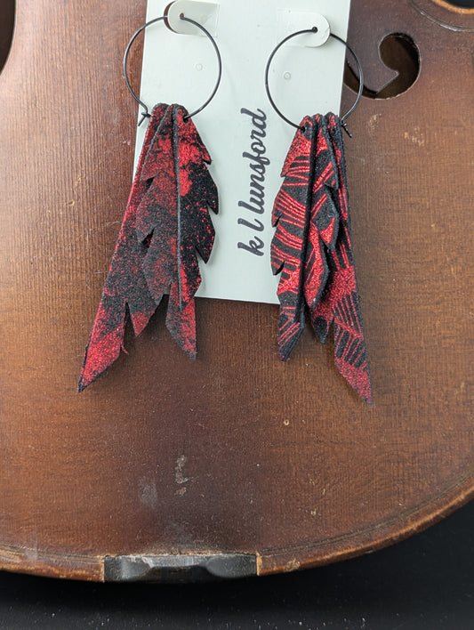 Leather earrings. Black with shimmery red on black hoops. 4 inches long.